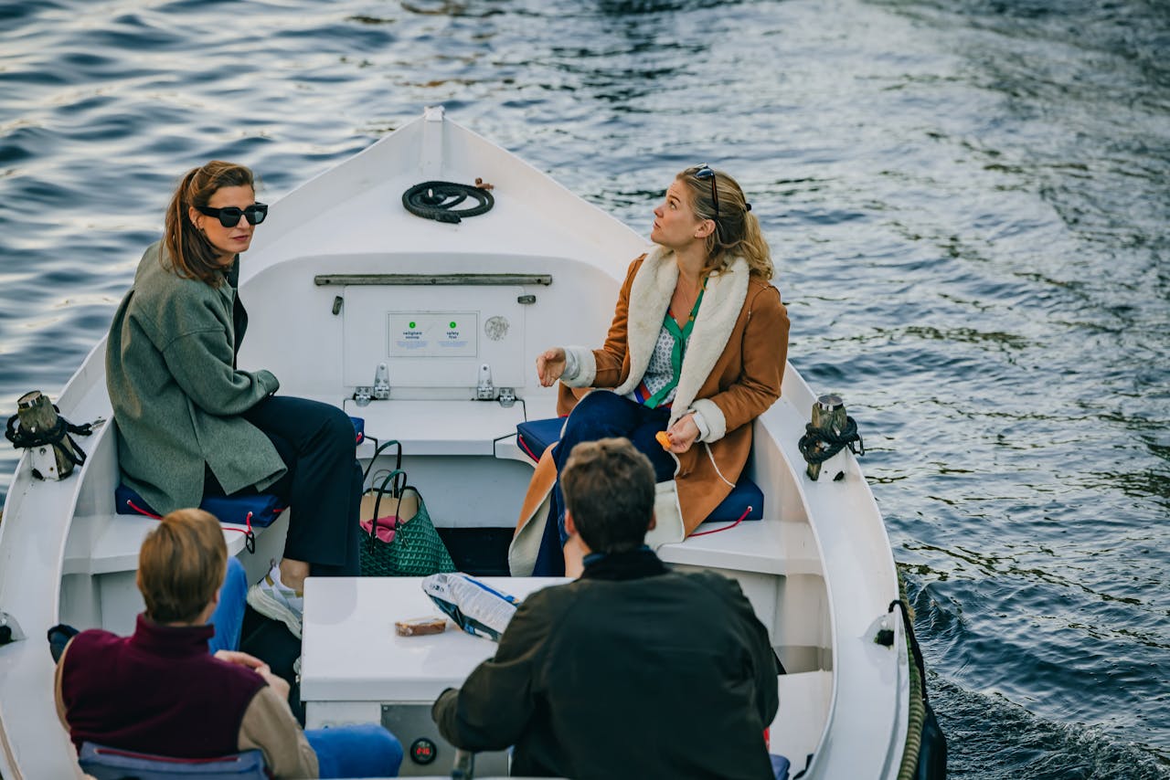 services-01 A group of tourists enjoying a leisurely boat ride on an Amsterdam canal.