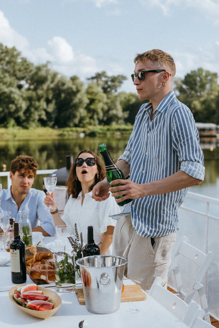 services-02 Three adults celebrating with wine on a yacht during a sunny day.