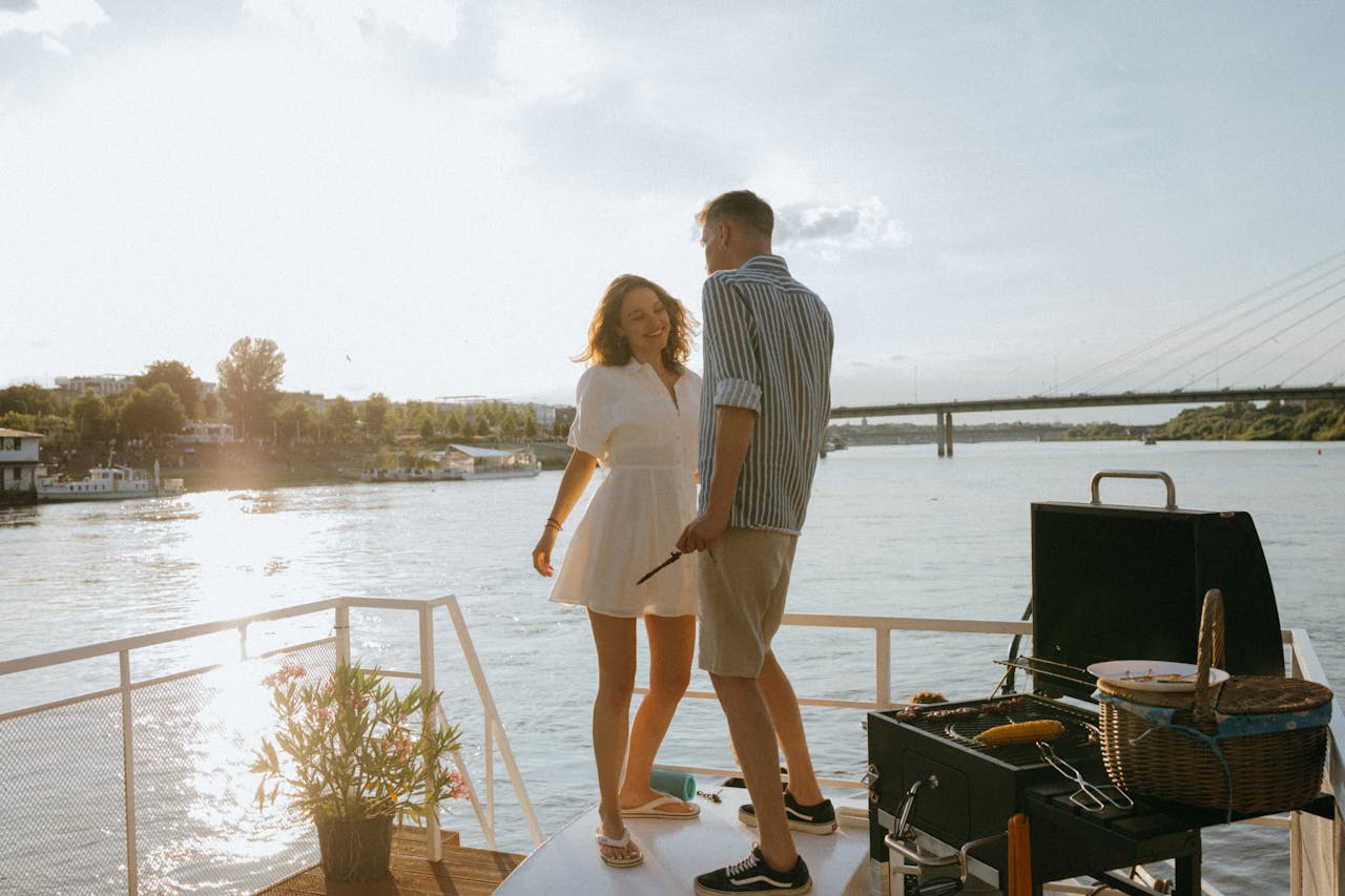 who-we-are A young couple enjoying a romantic barbecue on a yacht during a beautiful summer sunset.